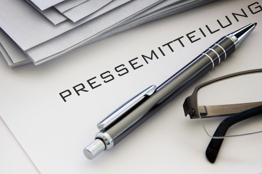 Kugelschreiber und Brille auf einem Zettel mit der Aufschrift