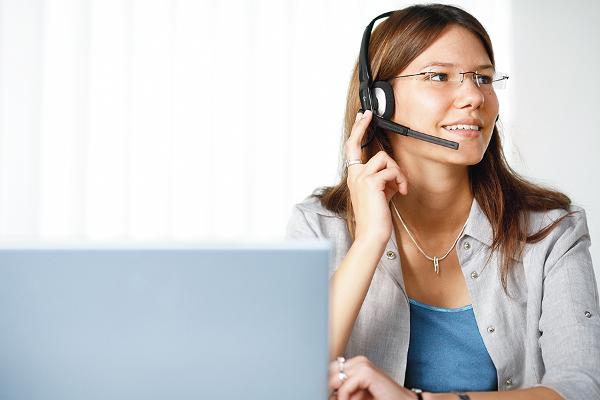 Junge Frau mit Headset beim Telefonieren