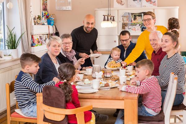Eine große Familie sitzt am Tisch und isst Kuchen Eine große Familie sitzt am Tisch und isst Kuchen