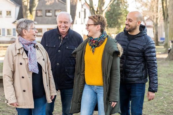 Eltern gehen mit ihrer erwachsenen Tochter und Schwiegersohn spazieren