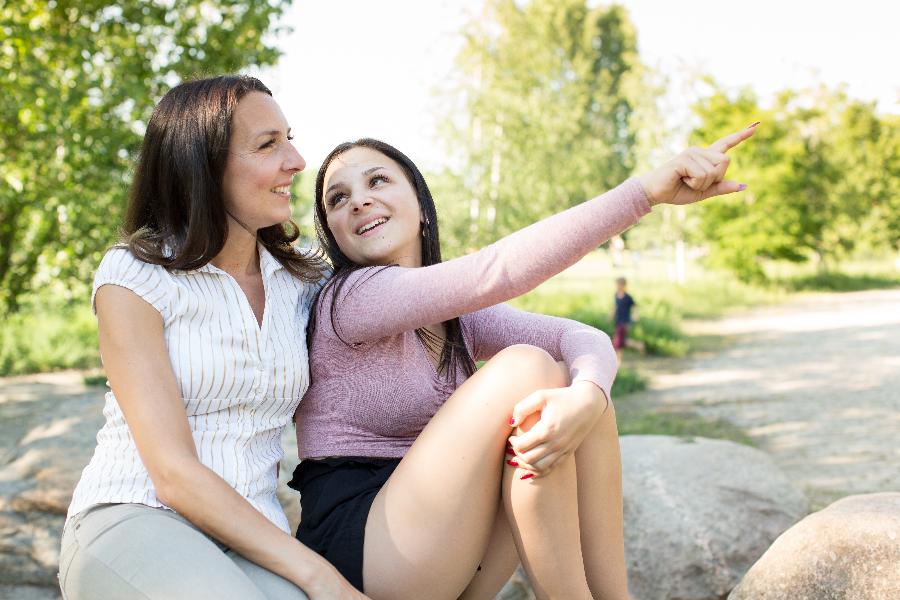 Mutter und Tochter sitzen zusammen im Freien Mutter und Tochter sitzen zusammen im Freien