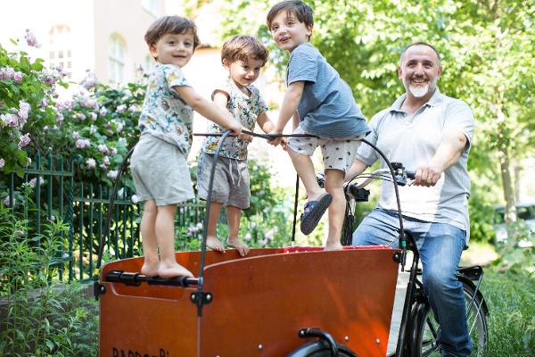 Vater fährt seine Kindern im Bollerwagen