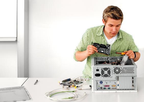 EIn junger Mann repariert einen PC. EIn junger Mann repariert einen PC.