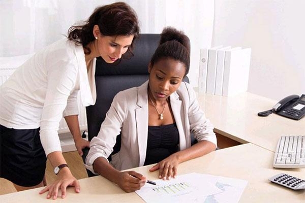 Zwei Damen am Schreibtisch schauen auf eine Grafik Zwei Damen am Schreibtisch schauen auf eine Grafik