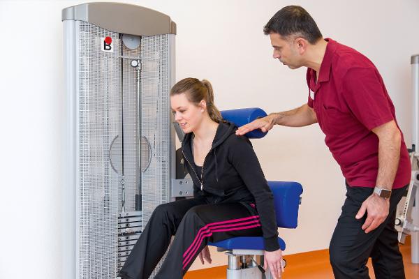 Eine junge Frau wird von einem Trainer beim Training betreut Eine junge Frau wird von einem Trainer beim Training betreut