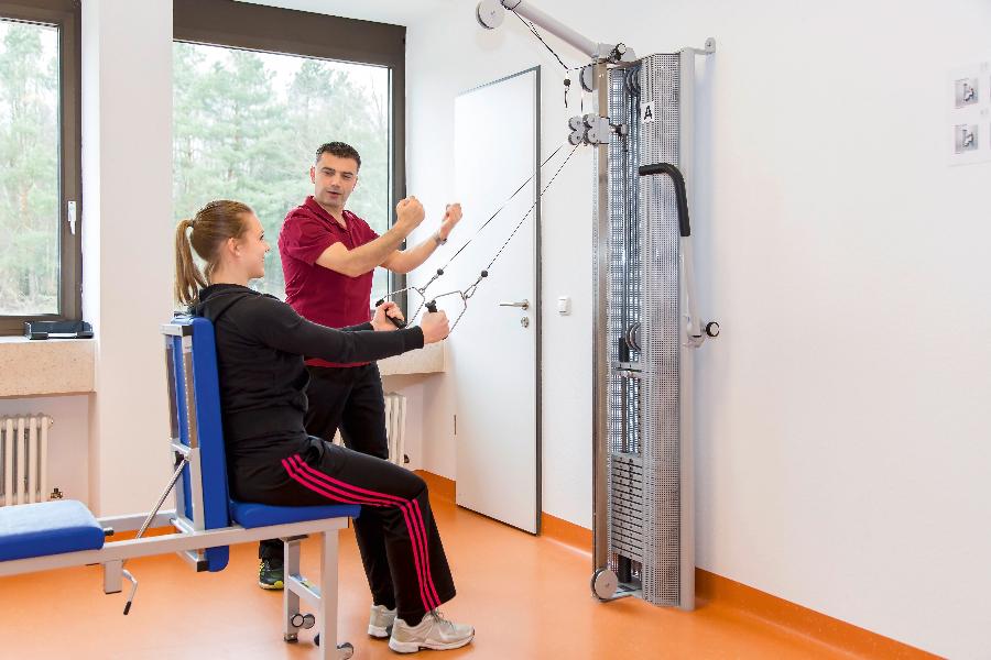 Eine junge Frau wird von einem Trainer beim Training betreut Eine junge Frau wird von einem Trainer beim Training betreut