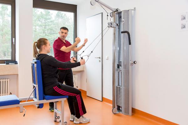 Eine junge Frau wird von einem Trainer beim Training betreut Eine junge Frau wird von einem Trainer beim Training betreut