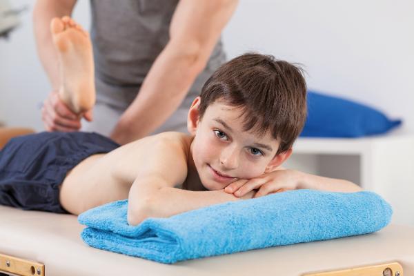 Ein Junge wird in der Physiotherapie behandelt Ein Junge wird in der Physiotherapie behandelt