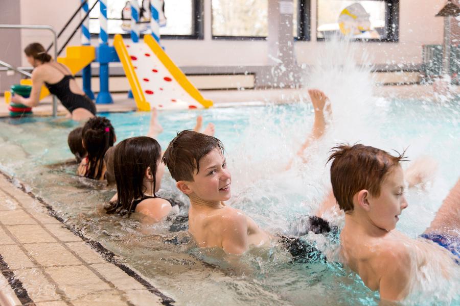 Eine Gruppe von Kindern planschen beim Schwimmtraining im Wasser Eine Gruppe von Kindern planschen beim Schwimmtraining im Wasser