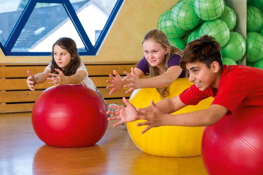 Eine Gruppe von Kindern trainiert mit Gymnastikbällen