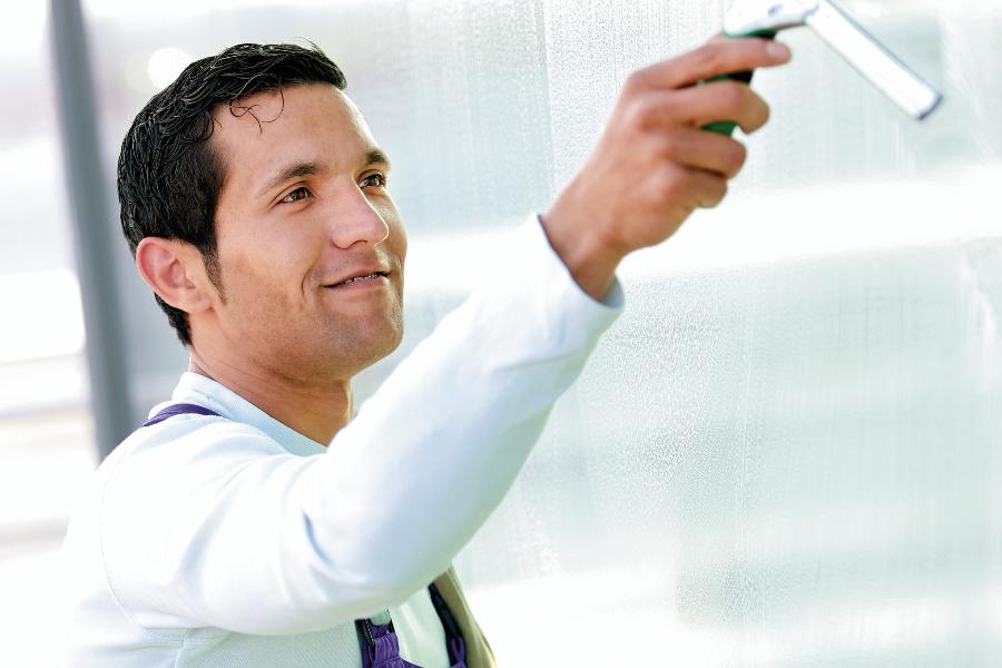 Ein Gebäudereiniger putzt Fenster Ein Gebäudereiniger putzt Fenster