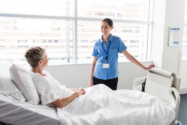 Eine Krankenpflegerin betreut eine Patientin im Krankenbett Eine Krankenpflegerin betreut eine Patientin im Krankenbett