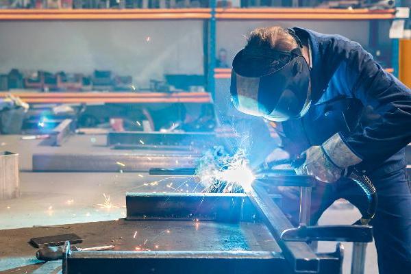 Ein Mann bei Schweißarbeiten in einer Werkstatt. Ein Mann bei Schweißarbeiten in einer Werkstatt.