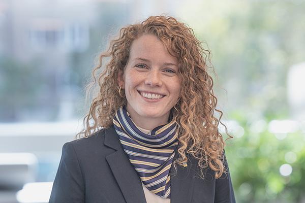 Eine junge Frau mit hellen lockigen Haaren. Sie trägt einen Blazer und ein gestreiftes Halstuch. Eine junge Frau mit hellen lockigen Haaren. Sie trägt einen Blazer und ein gestreiftes Halstuch.