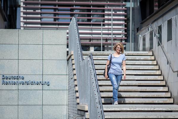 Eine Frau läuft die Treppe eines DRV-Gebäudes hinunter