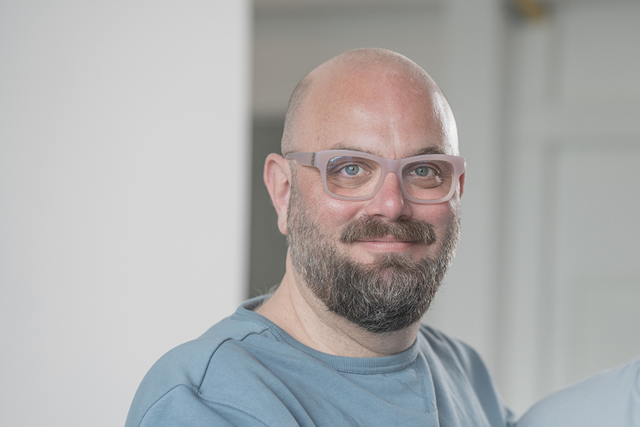 Porträt freundlicher Mann mittleres Alter mit Brille, Bart und Glatze Porträt freundlicher Mann mittleres Alter mit Brille, Bart und Glatze