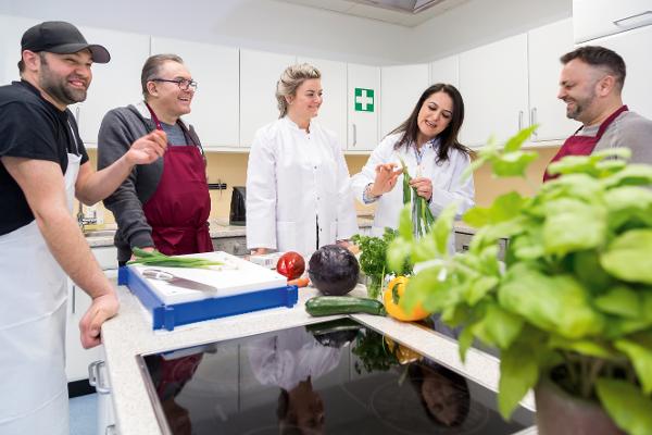 Eine Gruppe kocht in einem Kochstudio