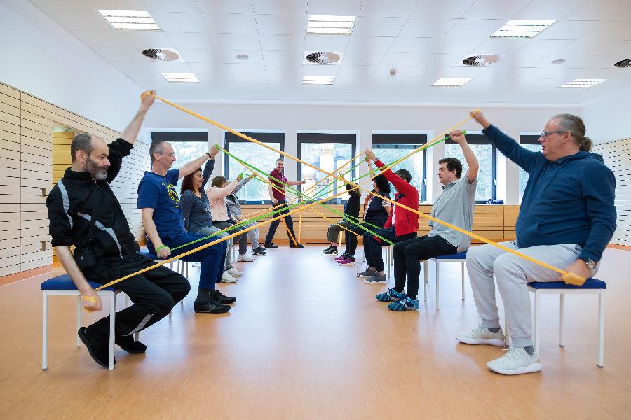 Eine Gruppe trainiert mit Gymnastikbändern