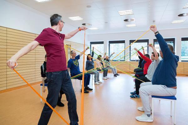 Eine Gruppe trainiert mit Gymnastikbändern