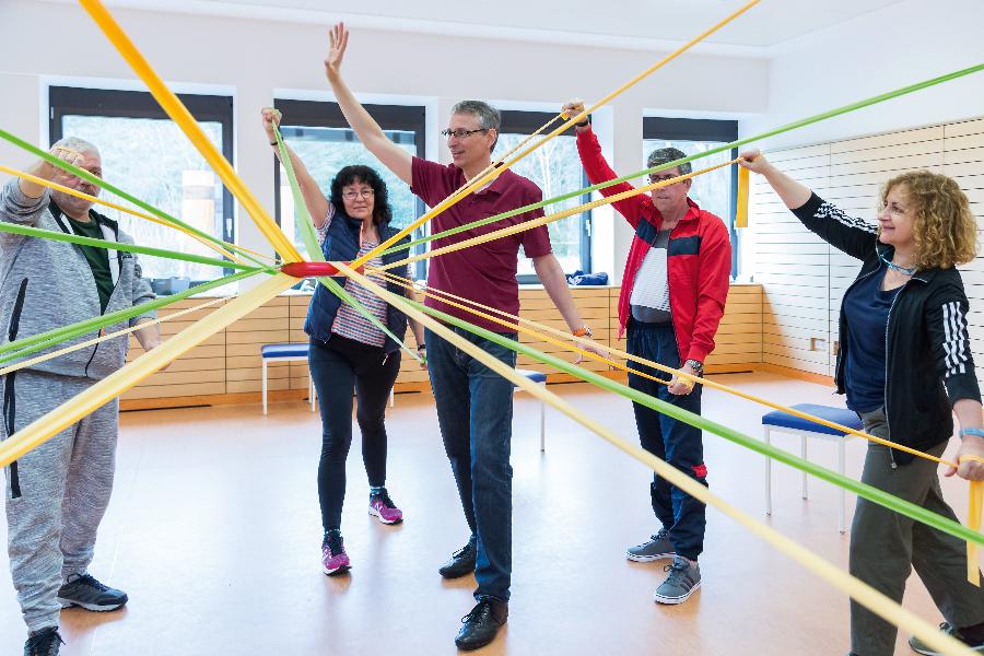 Eine Gruppe trainiert mit Gymnastikbändern