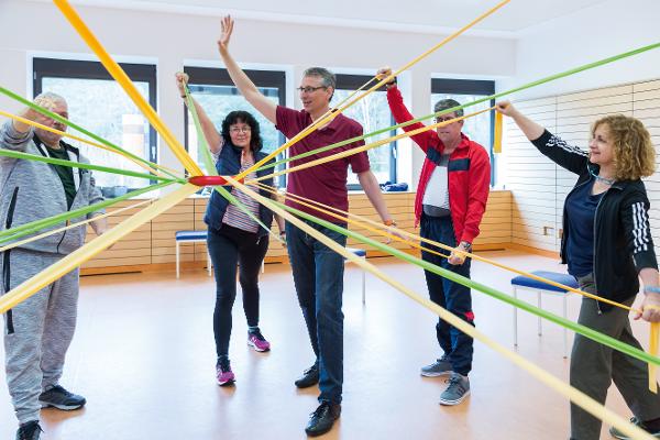 Eine Gruppe trainiert mit Gymnastikbändern Eine Gruppe trainiert mit Gymnastikbändern