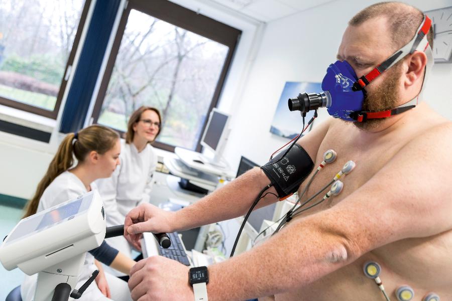 Ein Patient wird von medizinischem Personal beim Belastungs-EKG betreut Ein Patient wird von medizinischem Personal beim Belastungs-EKG betreut
