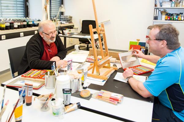 Zwei Männer zeichnen in einer Kreativwerkstatt Zwei Männer zeichnen in einer Kreativwerkstatt