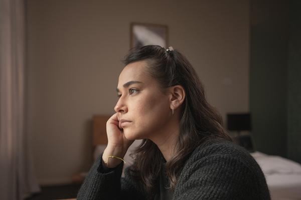 In schwarz gekleidete Frau schaut traurig aus dem Fenster In schwarz gekleidete Frau schaut traurig aus dem Fenster