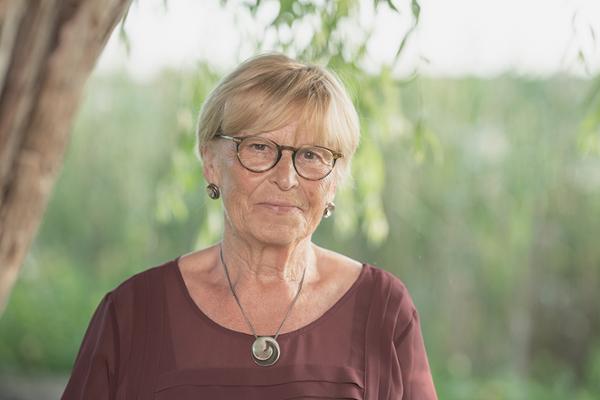 Lächelnde ältere Dame mit kurzen blonden Haaren und Brille  Lächelnde ältere Dame mit kurzen blonden Haaren und Brille