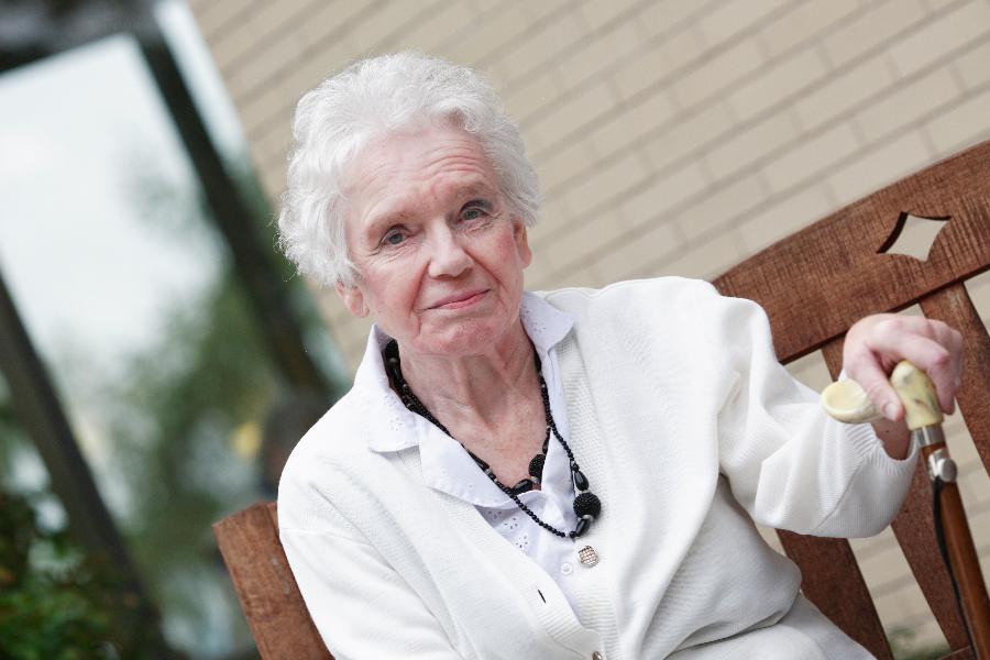 Eine Seniorin sitzt auf einer Bank. Eine Seniorin sitzt auf einer Bank.