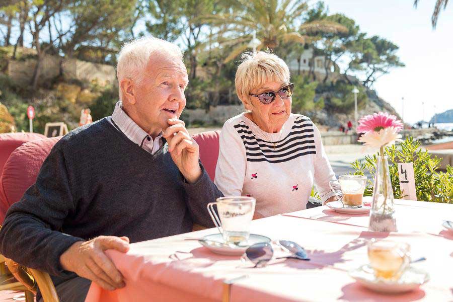 Zwei Senioren sitzen in einem Café am Tisch, sie esse Kuchen und trinken Kaffee Zwei Senioren sitzen in einem Café am Tisch, sie esse Kuchen und trinken Kaffee