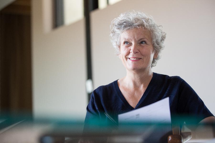 Eine ältere Dame freundlich lächelnd füllt ein Formular aus Eine ältere Dame freundlich lächelnd füllt ein Formular aus