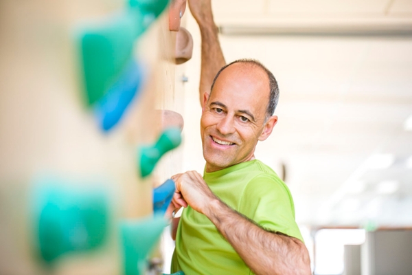 Ein Mann klettert an einer Kletterwand Ein Mann klettert an einer Kletterwand