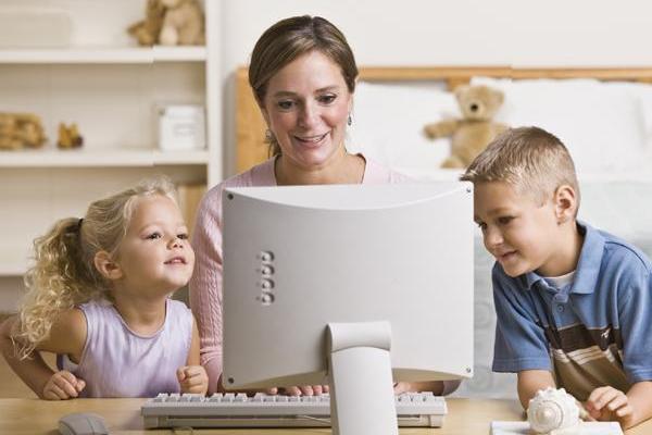 Mutter mit zwei Kindern arbeitet am Computer