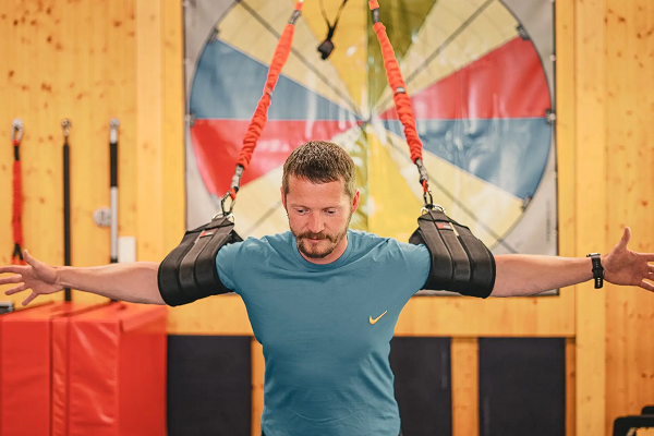 Ein Mann ist in ein Trainingsgerät eingespannt, um seinen Rücken zu trainieren Ein Mann ist in ein Trainingsgerät eingespannt, um seinen Rücken zu trainieren