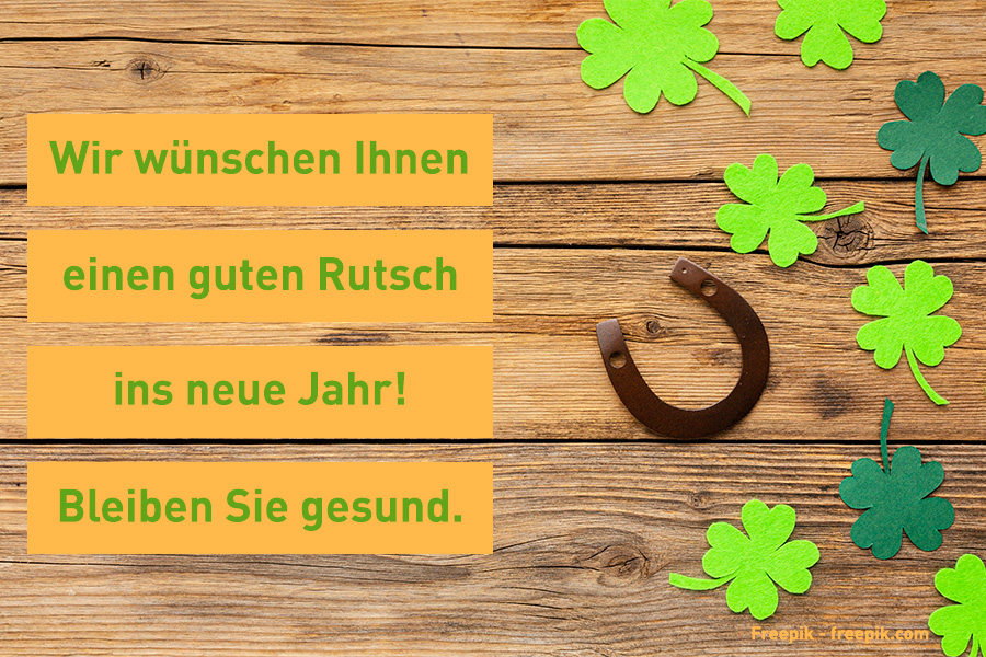 Auf dem Bild sind Kleeblätter aus grünem Stoff und ein Hufeisen auf einer Holzunterlage zu sehen. Wir wünschen Ihnen einen guten Rutsch ins neue Jahr! Auf dem Bild sind Kleeblätter aus grünem Stoff und ein Hufeisen auf einer Holzunterlage zu sehen. Wir wünschen Ihnen einen guten Rutsch ins neue Jahr!