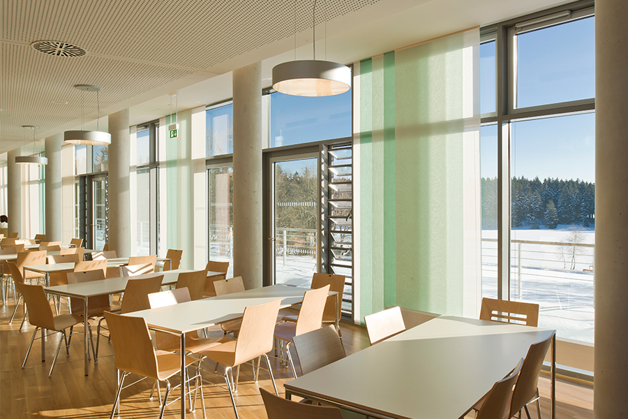Der Speisesaal im Rehazentrum Oberharz. Um weiße Tische herum stehen helle Holzstühle. Draußen liegt Schnee.