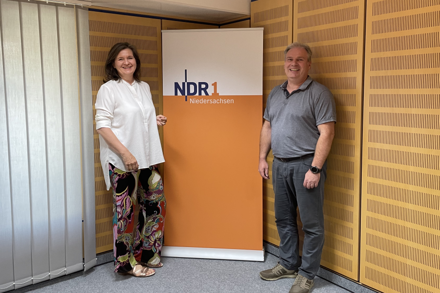 Auf dem Bild stehen NDR-Moderatorin Julia Vogt und Rentenberater Hagen Busse vor einem Plakat mit dem Logo von NDR 1 Niedersachsen. Auf dem Bild stehen NDR-Moderatorin Julia Vogt und Rentenberater Hagen Busse vor einem Plakat mit dem Logo von NDR 1 Niedersachsen.