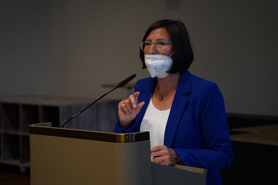 Die alternierende Vorstandsvorsitzende Helga Schwitzer steht in einem blauen Jacket am Rednerpult.  Die alternierende Vorstandsvorsitzende Helga Schwitzer steht in einem blauen Jacket am Rednerpult.