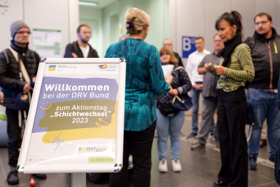 Eine Gruppe von Menschen steht in einem Eingangsbereich Eine Gruppe von Menschen steht in einem Eingangsbereich