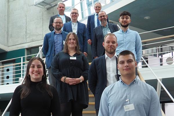 Auf dem Bild sind fünf junge Menschen zu sehen, die in die Kamera lächeln. Hinter ihnen stehen fünf lächelnde Führungskräfte der DRV Nord, die sie begrüsst haben. Auf dem Bild sind fünf junge Menschen zu sehen, die in die Kamera lächeln. Hinter ihnen stehen fünf lächelnde Führungskräfte der DRV Nord, die sie begrüsst haben.