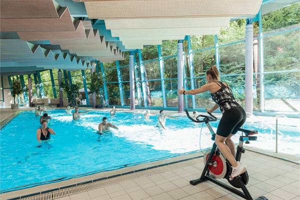 Eine Therapeutin trainiert am Schwimmbecken mehrere Patientinnen und Patienten. Eine Therapeutin trainiert am Schwimmbecken mehrere Patientinnen und Patienten.