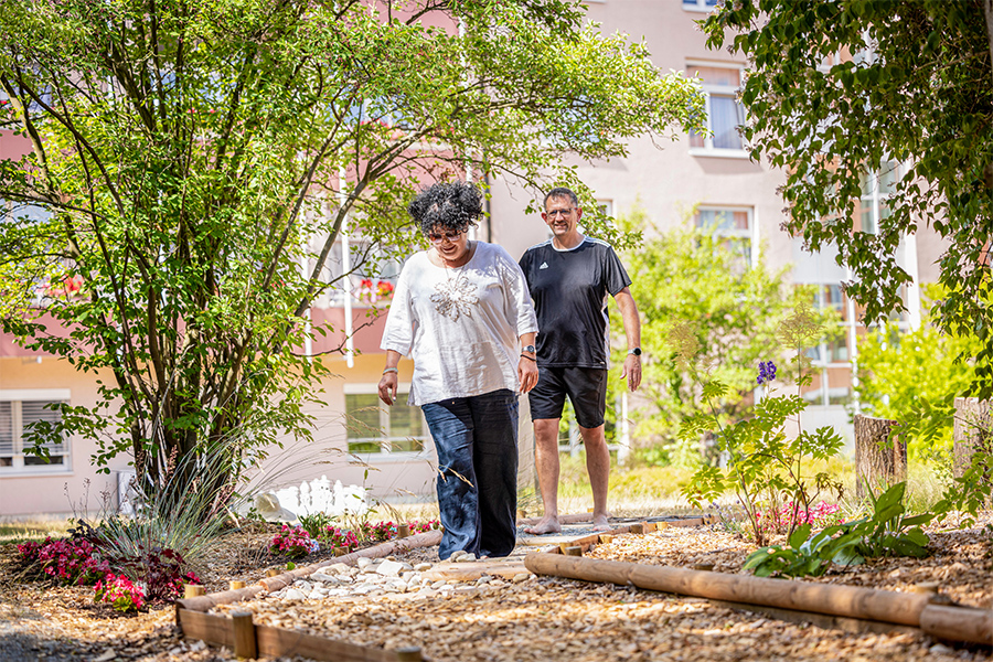 Zwei Patienten laufen über einen Barfußpfad. Zwei Patienten laufen über einen Barfußpfad.