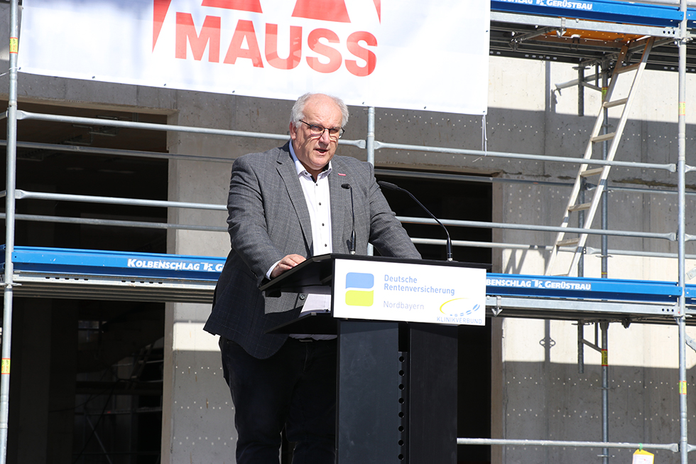 Reinhard Bauer, Vorsitzender des Bau- und Grundstücksausschusses der DRV Nordbayern, verkündet feierlich den Namen des neuen Rehazentrums der DRV Nordbayern. Reinhard Bauer, Vorsitzender des Bau- und Grundstücksausschusses der DRV Nordbayern, verkündet feierlich den Namen des neuen Rehazentrums der DRV Nordbayern.
