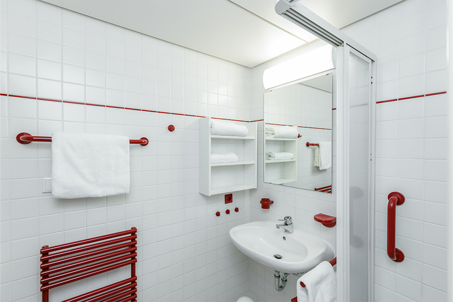 Aufnahme eines Badezimmers in der Klinik mit Spiegel, Waschtisch und Handtuchheizkörper. Aufnahme eines Badezimmers in der Klinik mit Spiegel, Waschtisch und Handtuchheizkörper.