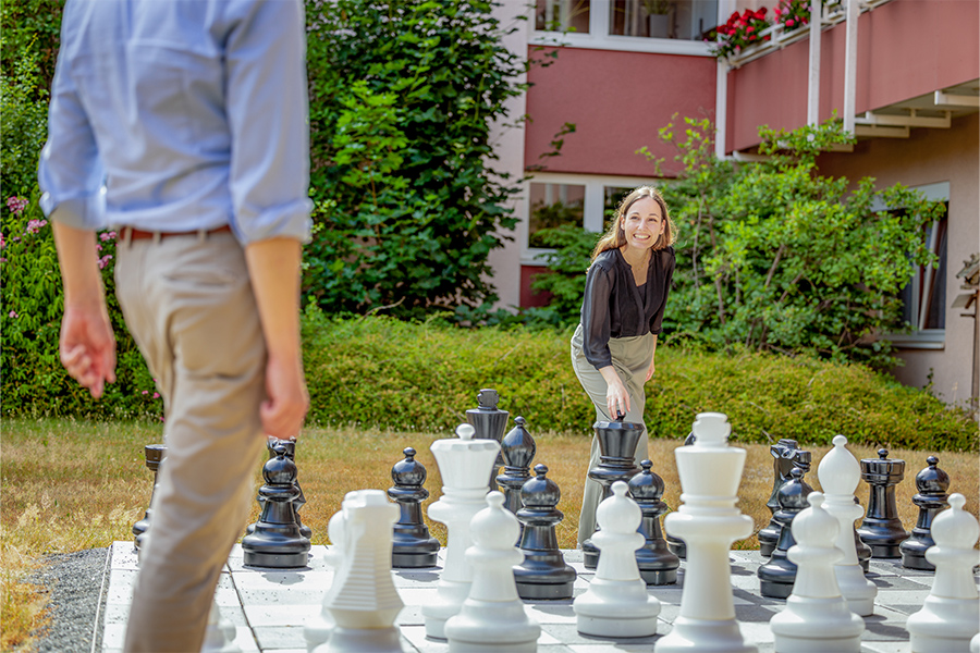 Zwei Personen spielen draußen auf einem Großfigurenspiel Schach. Zwei Personen spielen draußen auf einem Großfigurenspiel Schach.