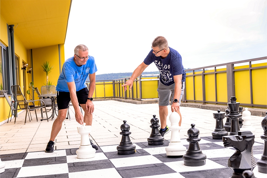 Zwei Männer spielen Schach auf einem Außenschachbrett. Zwei Männer spielen Schach auf einem Außenschachbrett.