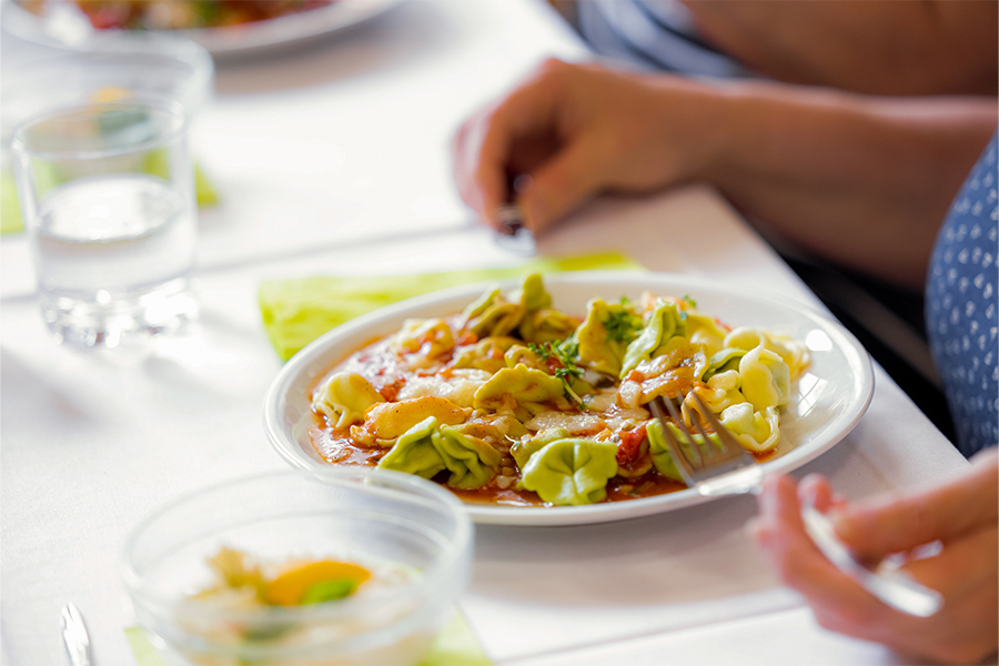 Auf einem Teller sind Tortellini mit Tomatensoße angerichtet. Auf einem Teller sind Tortellini mit Tomatensoße angerichtet.
