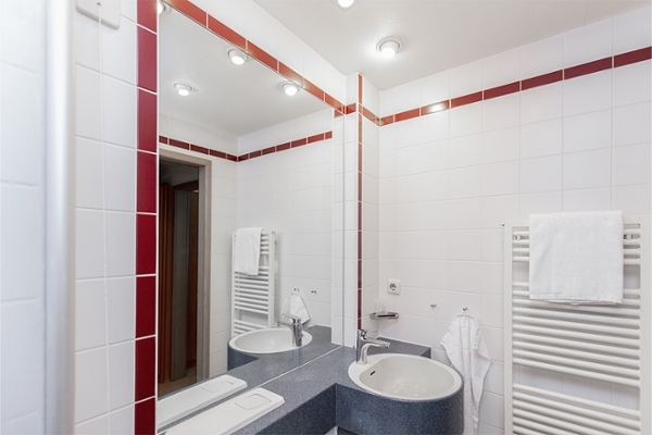 Aufnahme eines Badezimmers in der Klinik mit Spiegel, Waschtisch und Handtuchheizkörper. Aufnahme eines Badezimmers in der Klinik mit Spiegel, Waschtisch und Handtuchheizkörper.