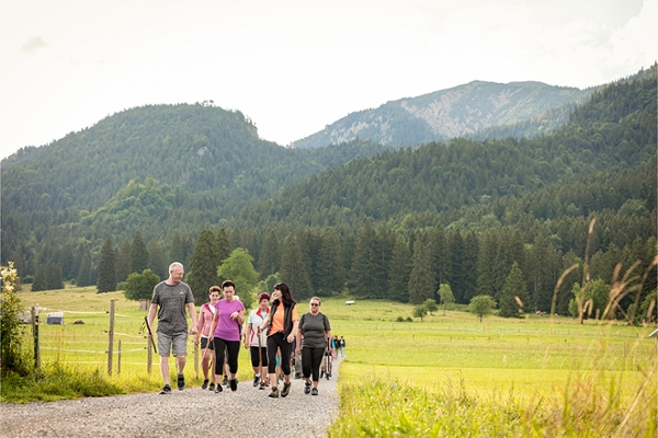 Mehrere Wanderer gehen auf einem Weg durch ein Feld spazieren. Mehrere Wanderer gehen auf einem Weg durch ein Feld spazieren.